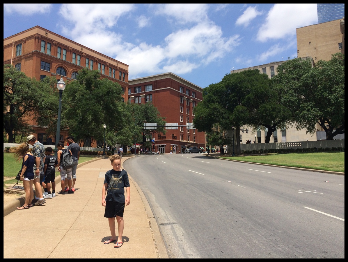The building on the left is where Oswald hid and waited to the President's motorcade. The "x" on the street on the right was where the first shot hit.